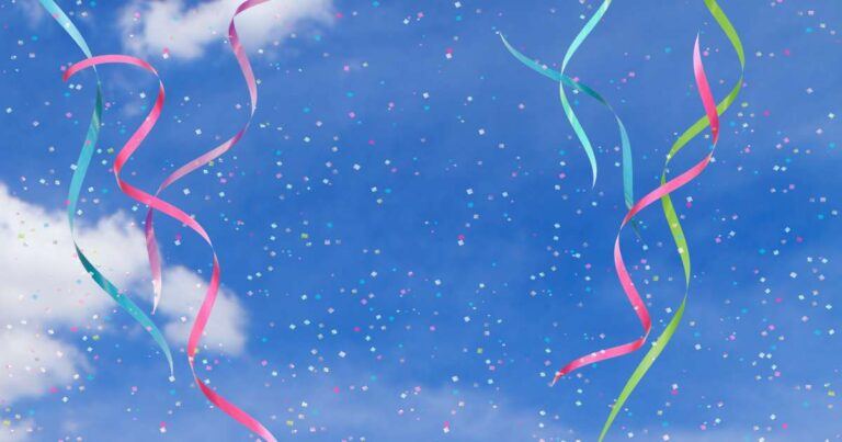 confetti and ribbons against a blue sky with clouds