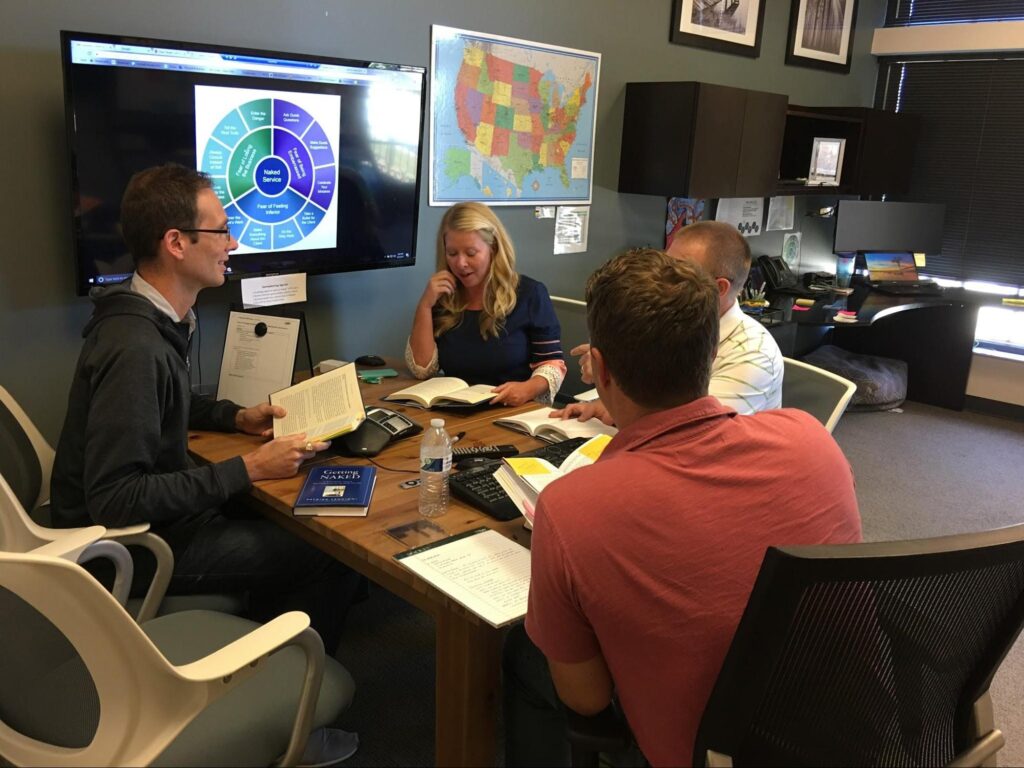 SEP team members at a table discussing a book