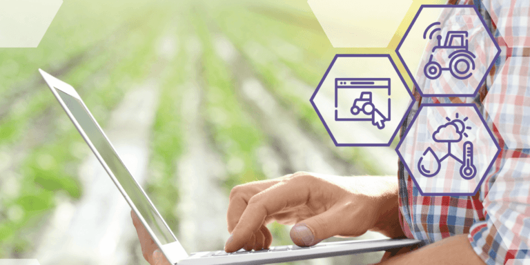 close up of man on laptop in front of crop field
