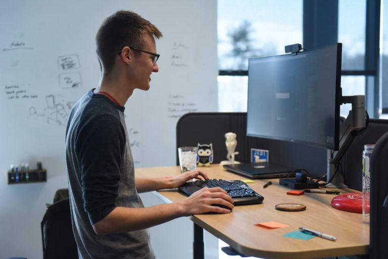 software developer working at computer at standing desk