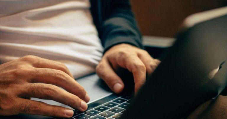close up of person typing on keyboard on laptop