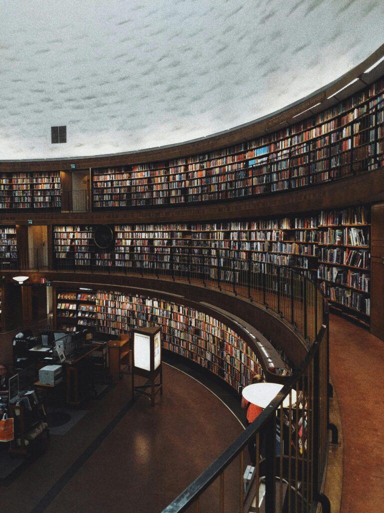 View of the inside of a three-story library with curved walls filled with books