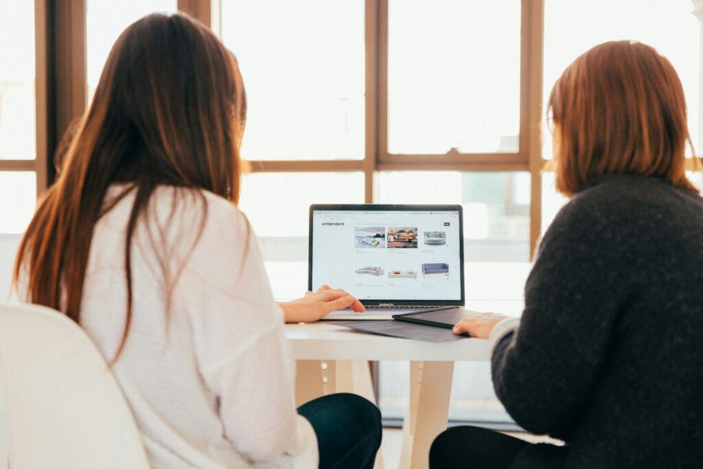 two women review content on a computer screen