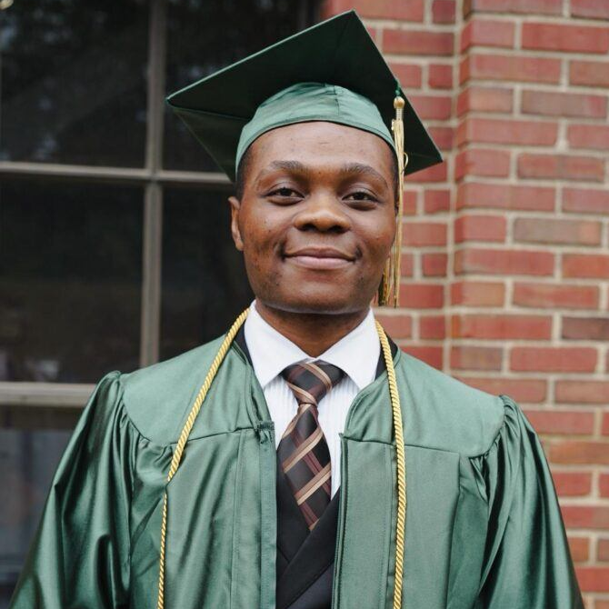 high school graduate in green cap and gown