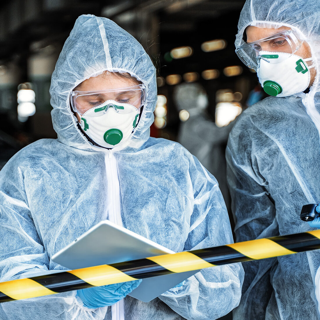 first responders in safety gear on tablet in the field