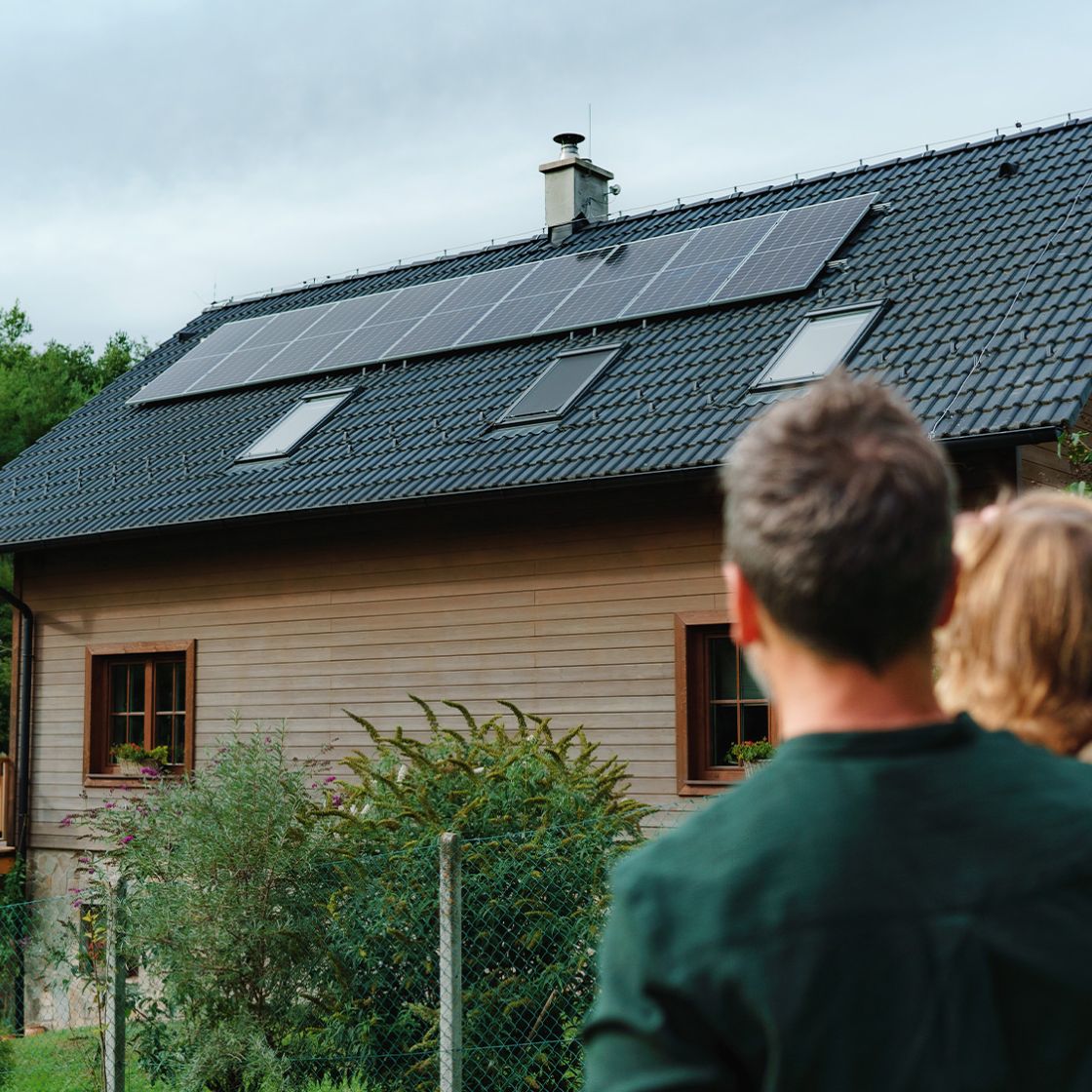 solar panel on top of house with family looking