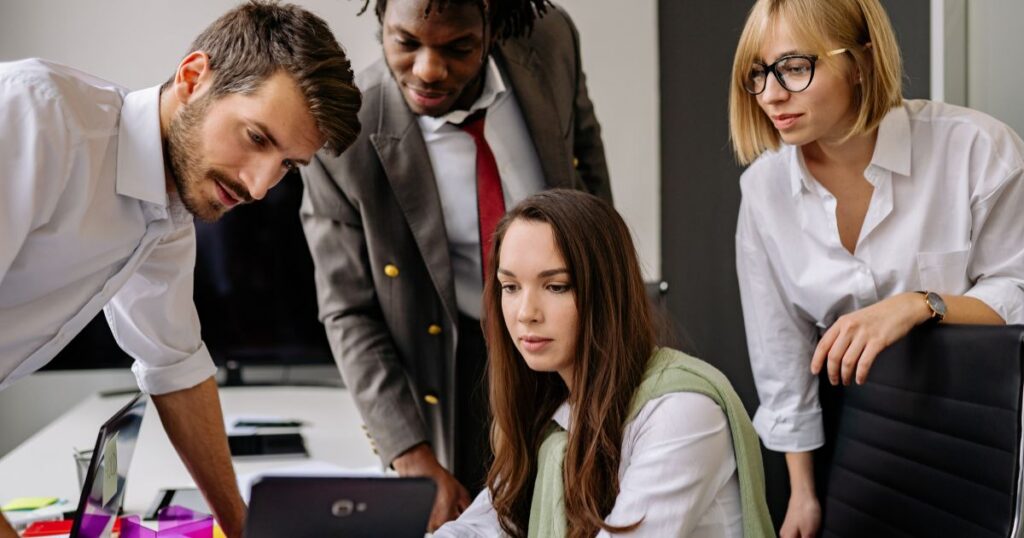 group of professionals collaborating around one screen